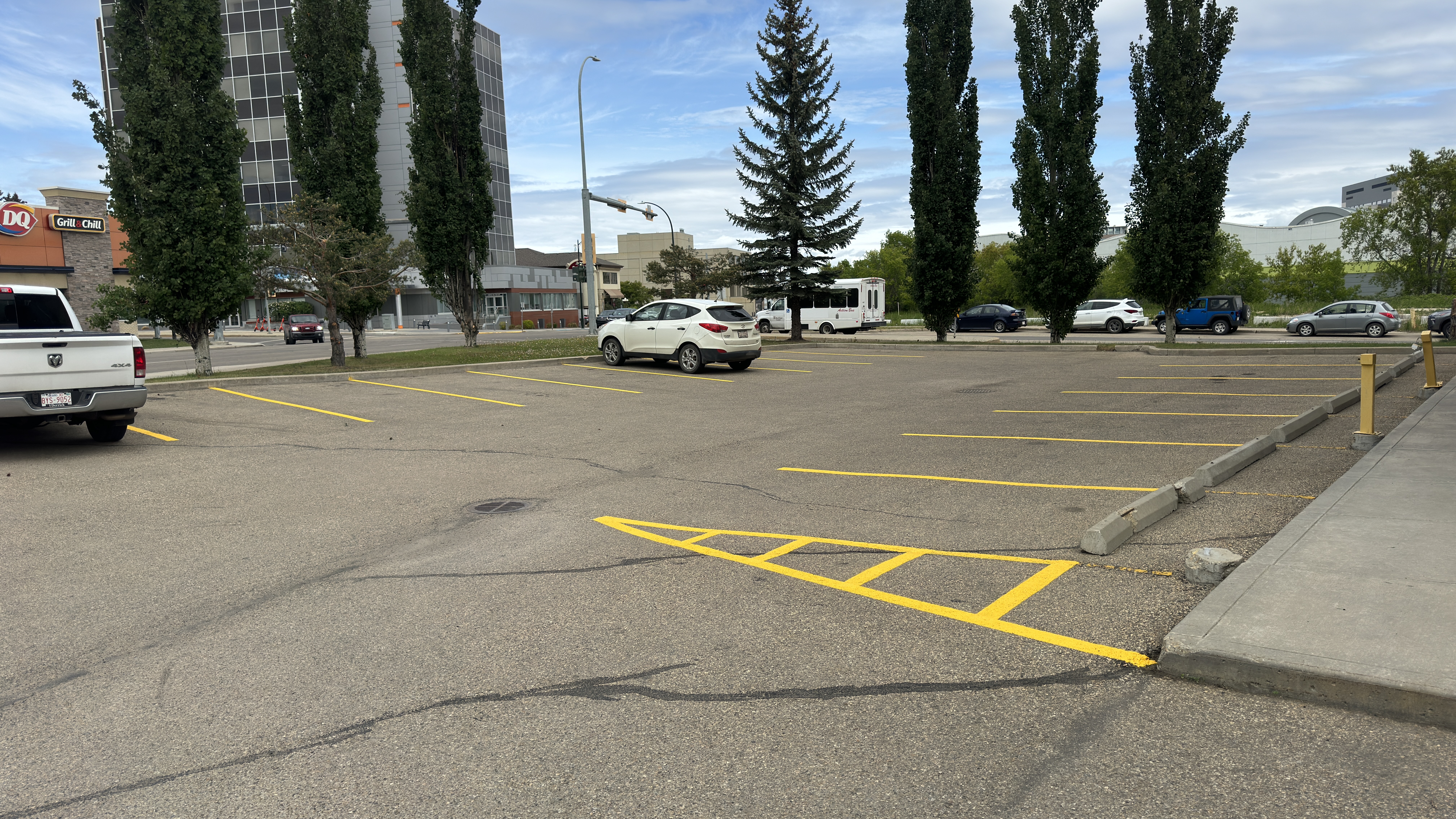 Freshly painted commercial parking lot with yellow crosshatch markings — Red Deer, AB