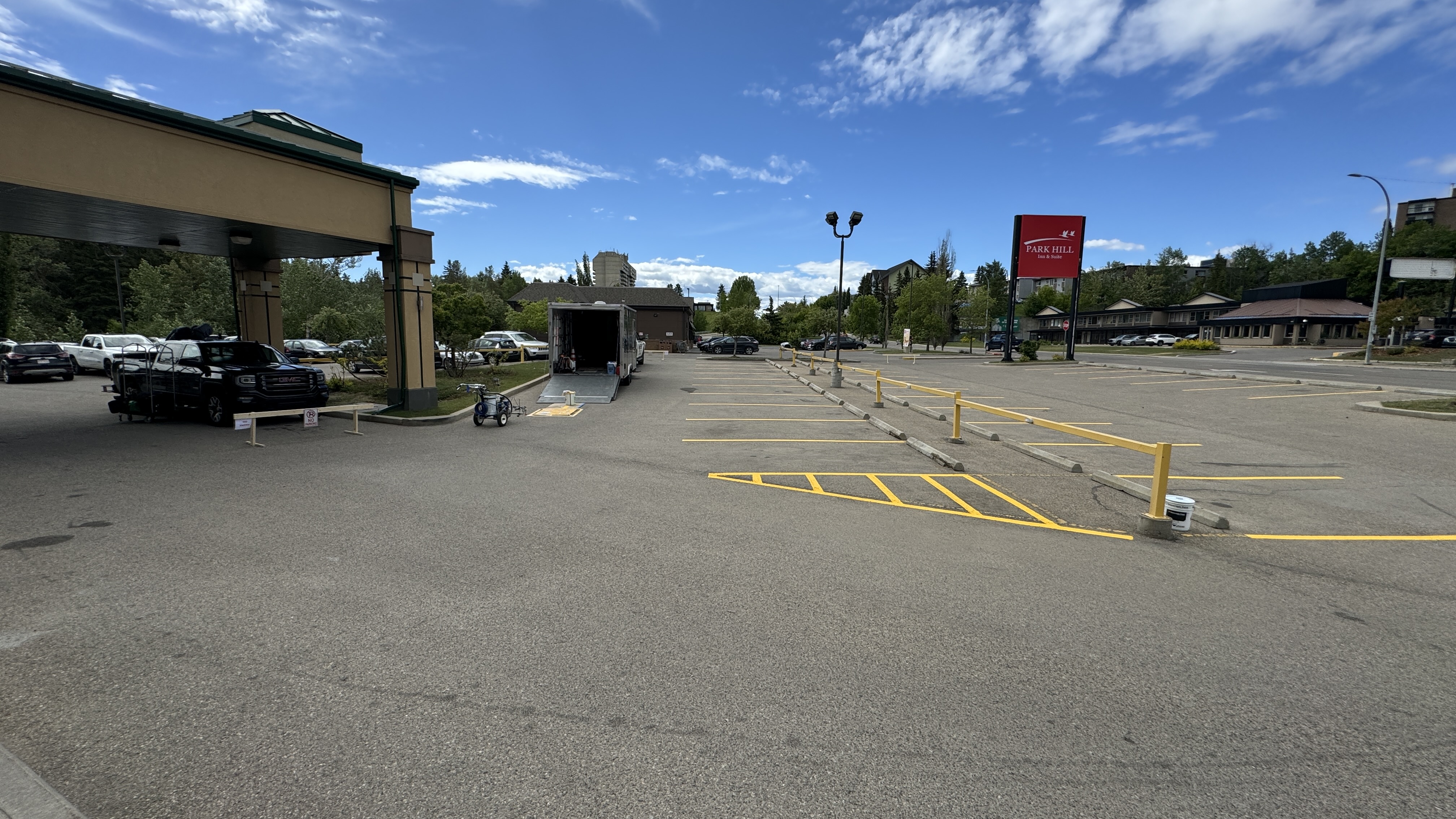 Commercial parking lot with fresh yellow bollard and crosshatch markings — Red Deer, AB