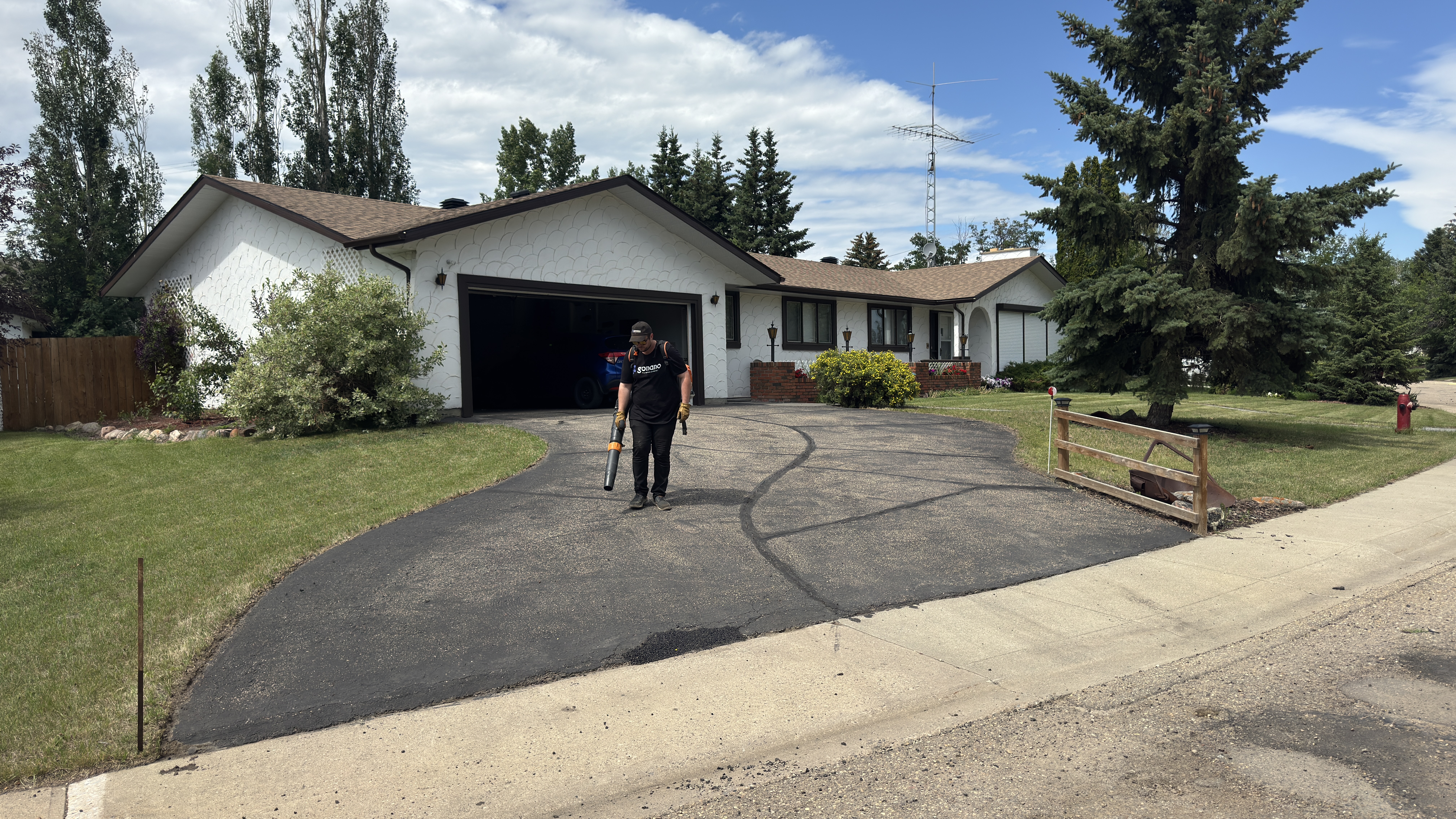 Driveway with crew performing cleanup after crack filling in Trochu